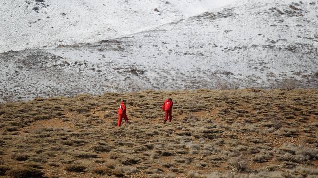 Members of emergency and rescue team search for the plane that crashed in a mountainous area of central Iran