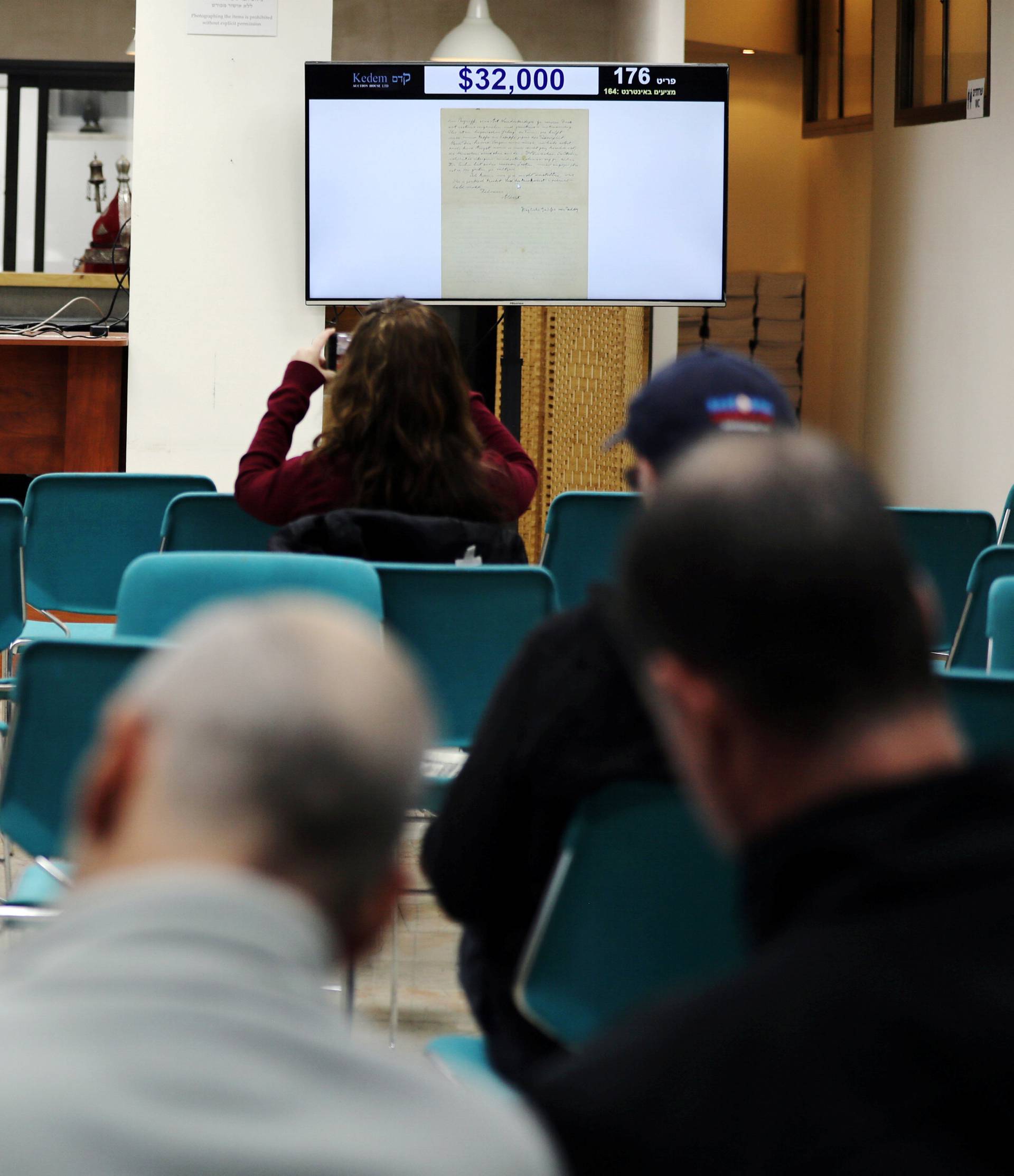 People attend a public auction where a letter written in 1922 by physicist Albert Einstein is put up for sale at Kedem Auction House in Jerusalem