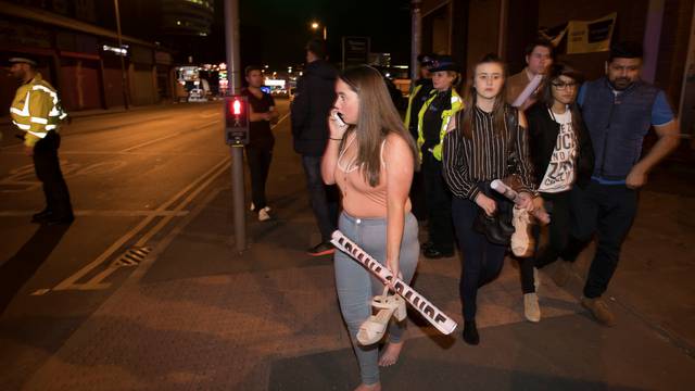 Concert goers react after fleeing the Manchester Arena in northern England where U.S. singer Ariana Grande had been performing in Manchester