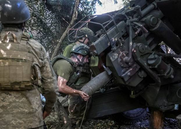 FILE PHOTO: Ukrainian servicemen fire a howitzer towards Russian troops at a position near the frontline town of Kramatorsk