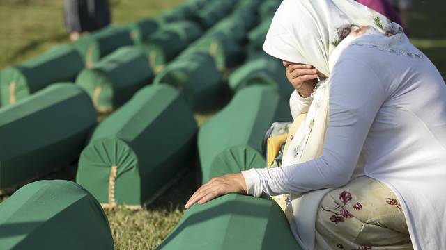 A Woman cries near coffins of her relatives, who are newly identified victims of the 1995 Srebrenica massacre, which are lined up for a joint burial in Potocari near Srebrenica