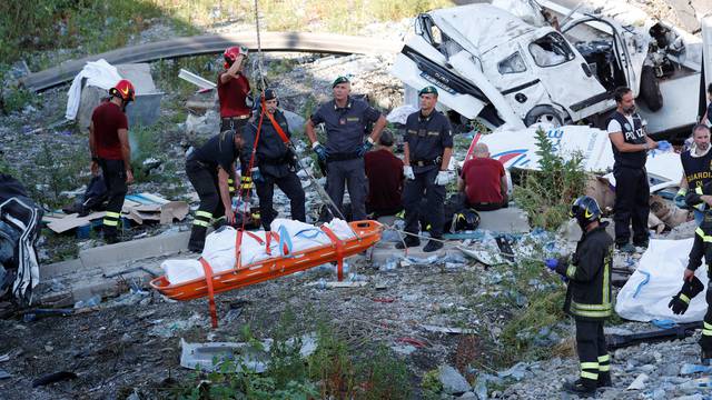 Rescue workers recover a body at the site of the collapsed Morandi Bridge in the Italian port city of Genoa