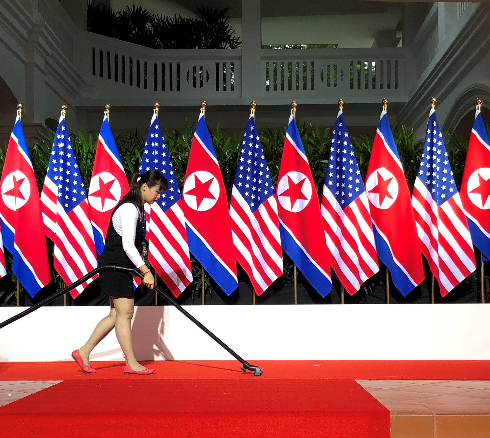 Worker vacuums spot where U.S. President Trump and North Korea's leader Kim are expected to  shake hands at start of their summit in Singapore