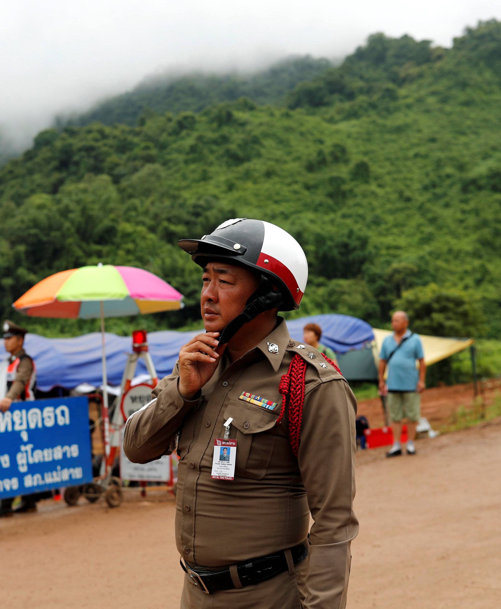 A police officerstands guard at a checkpoint outside the Tham Luang cave complex after Thailand's government instructed members of the media to move out urgently, in the northern province of Chiang Rai
