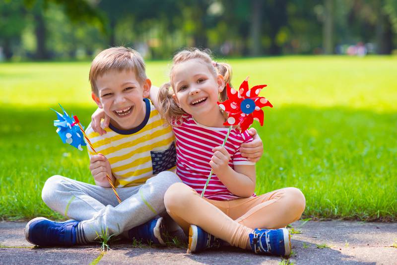 Two happy children playing with windmill