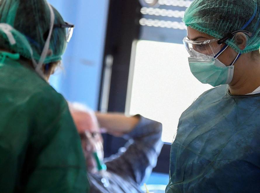 Medical staff wearing protective masks, glasses and suits treat patients suffering from coronavirus disease (COVID-19) in an intensive care unit at the Oglio Po hospital in Cremona