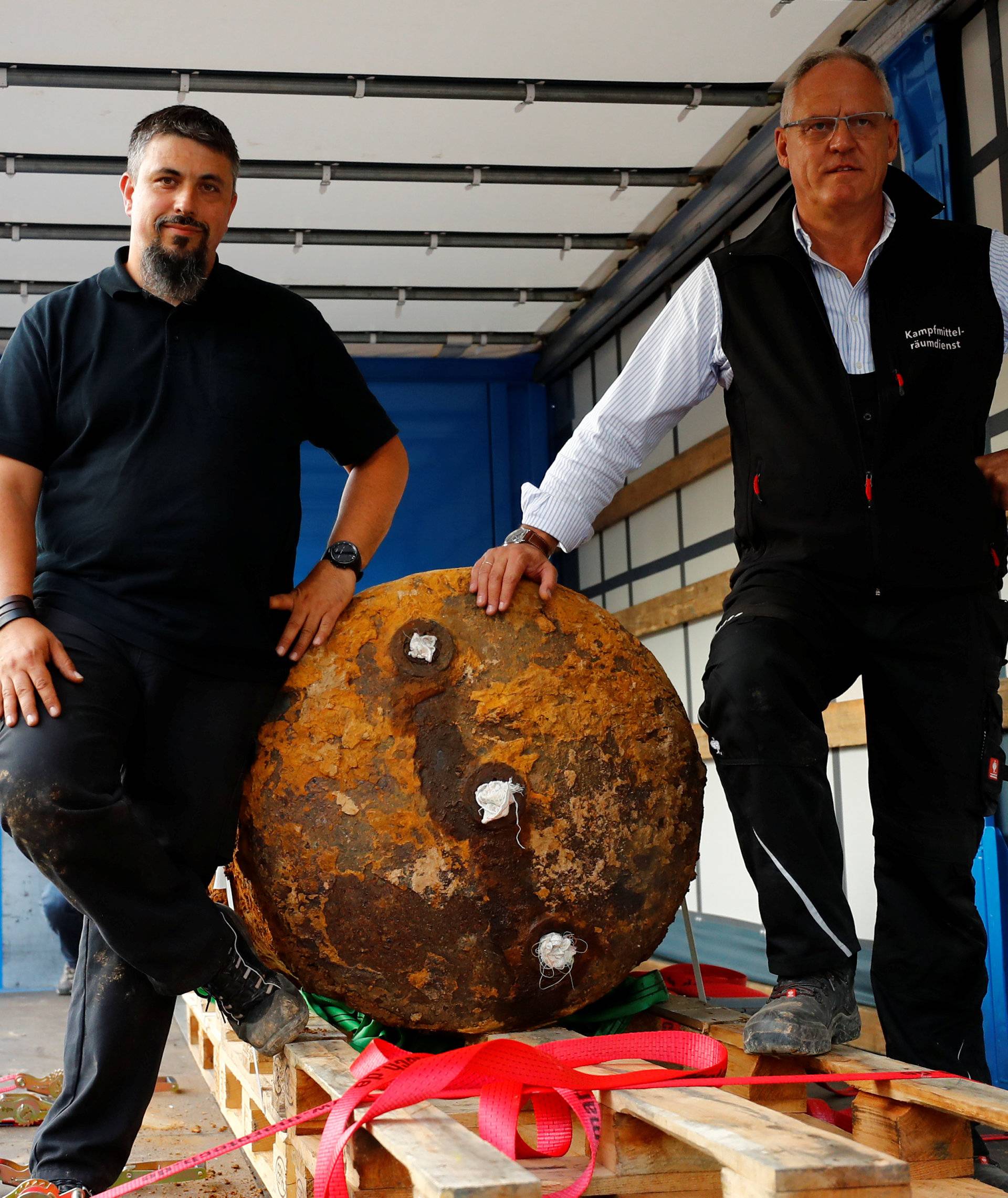 Bomb disposal experts Rene Bennert and Dieter Schweizler pose next to defused massive World War Two bomb after tens of thousands of people evacuated their homes in Frankfurt