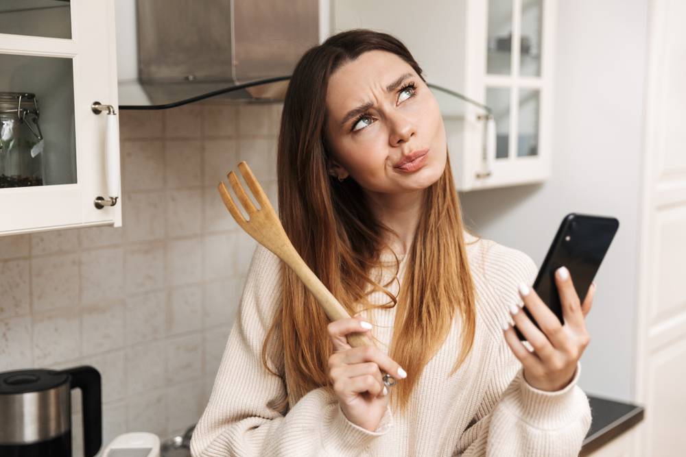 Lovely,Young,Woman,Cooking,While,Standing,At,The,Kitchen,At