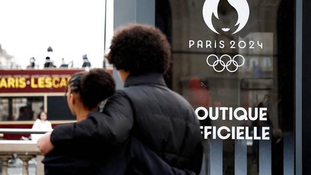 FILE PHOTO: People walk near the logo of the Paris 2024 Olympic and Paralympic Games on an official Paris 2024 store in Paris