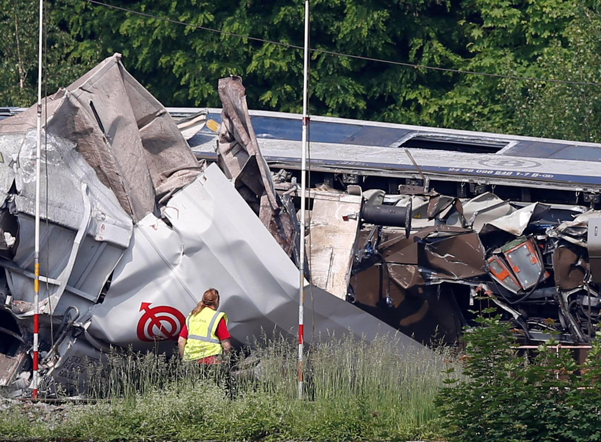 An official inspects the wreckage of a passenger train after it crashed into the back of a freight train, in the eastern Belgian municipality of Saint-Georges-Sur-Meuse