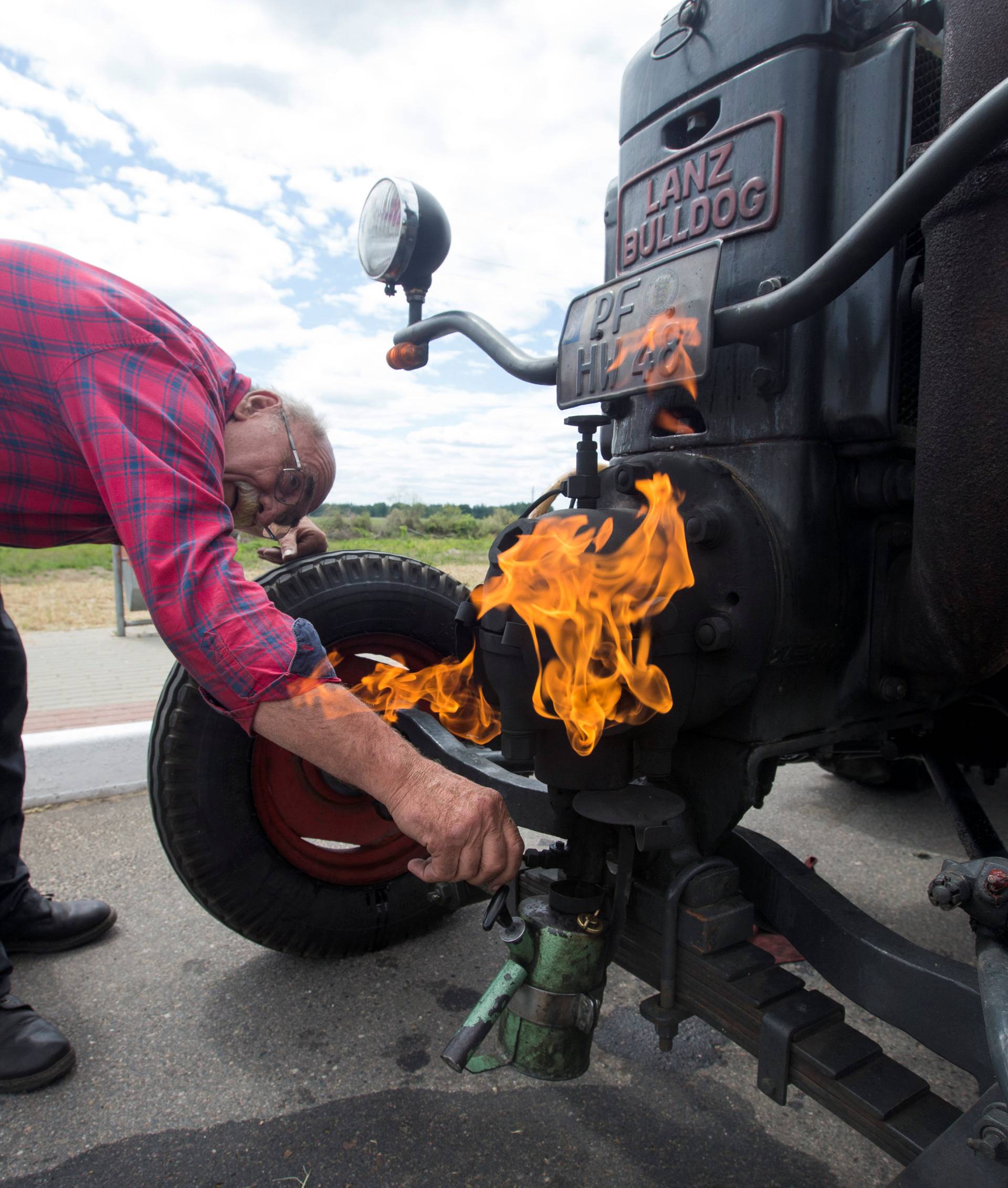 Soccer fan from Pforzheim, Germany, Wirth, 70, warms his tractor's engine to start it as he travels to attend the FIFA 2018 World Cup in Russia near the village of Yasen