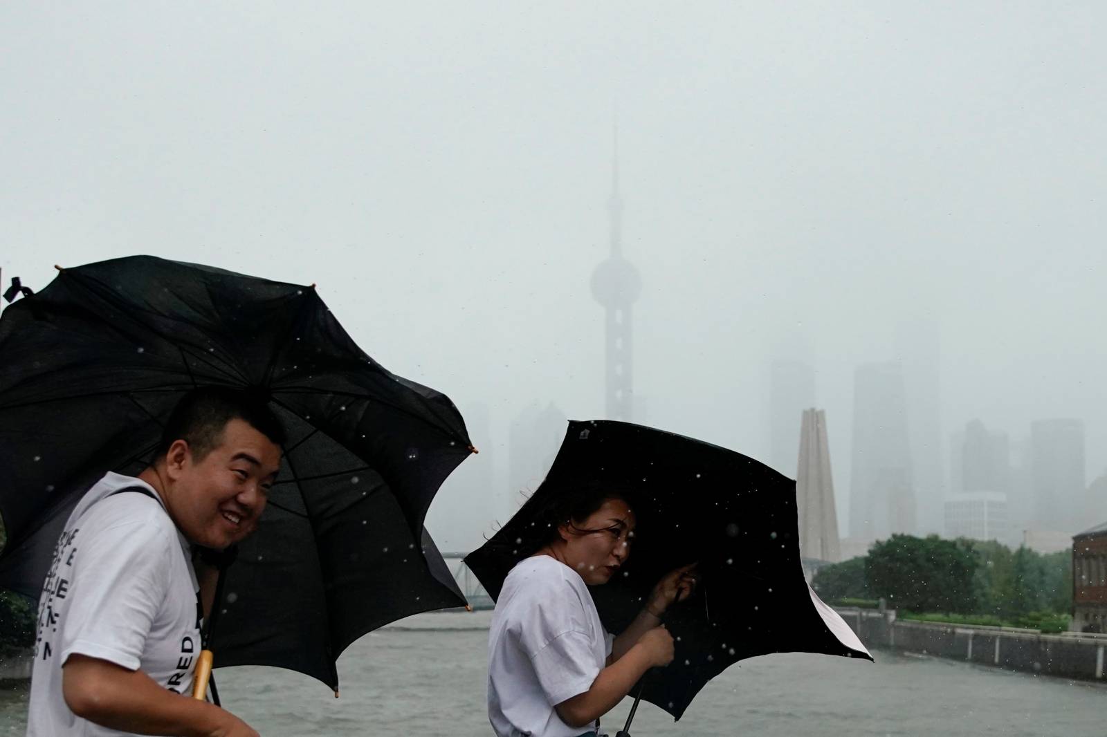 People walk in the rainstorm as typhoon Lekima approaches in Shanghai