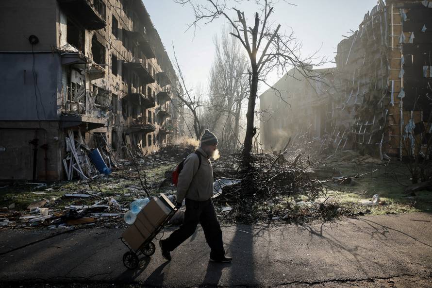 A resident walks near apartment buildings damaged by a Russian military strike in the frontline town of Kostiantynivka