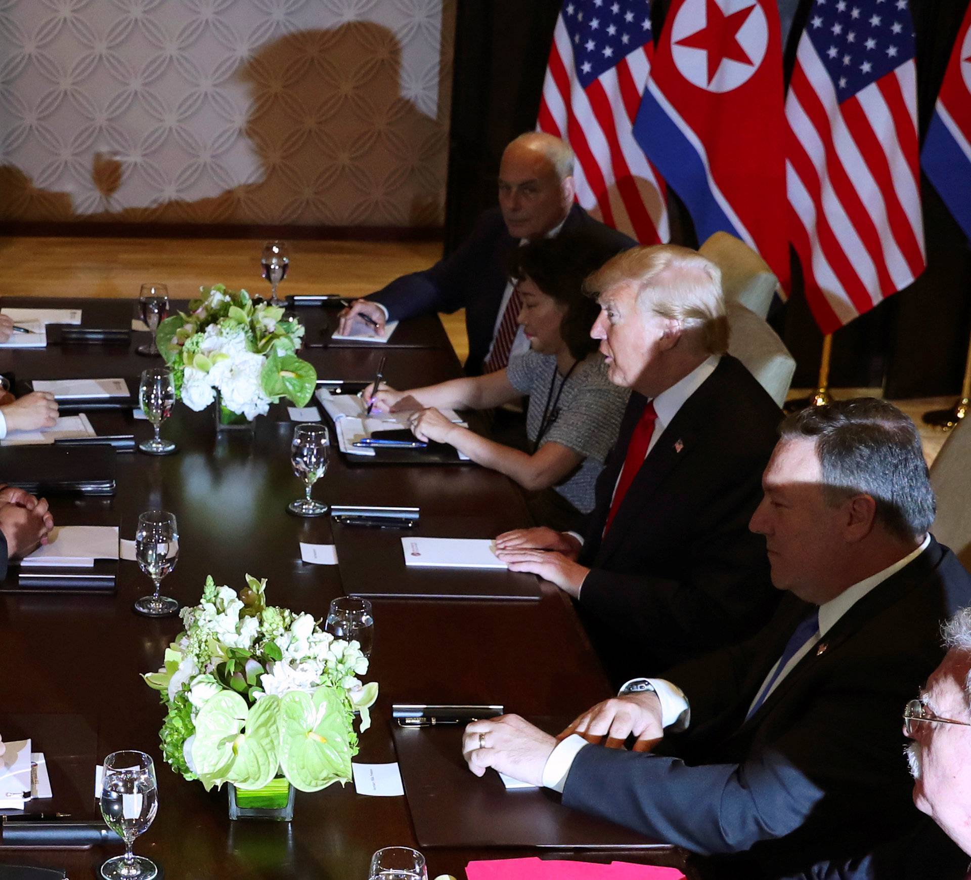 U.S. President Donald Trump speaks with North Korea's leader Kim Jong Un before their meeting in Singapore