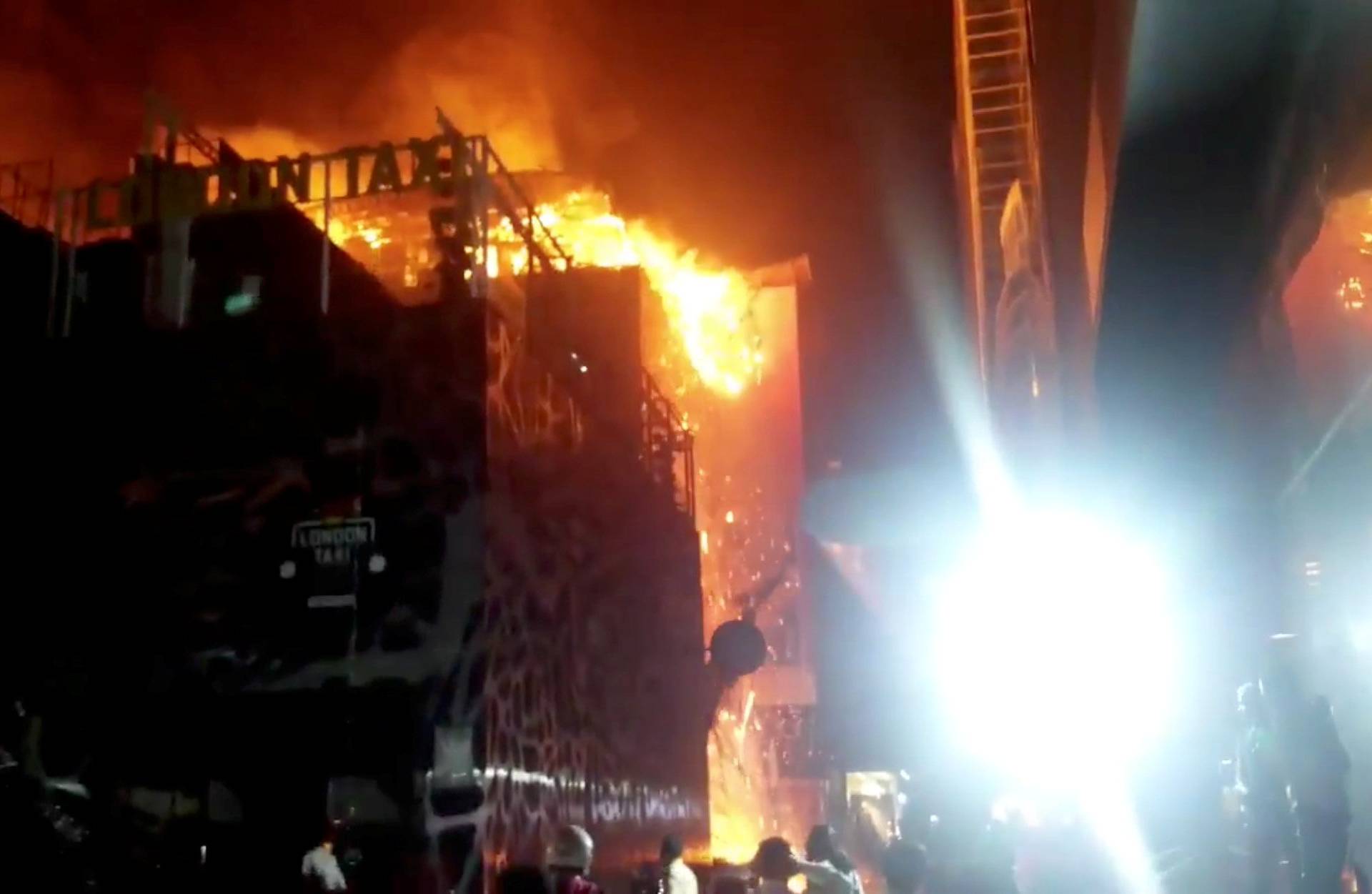 Debris falls from a building on fire in Mumbai, India