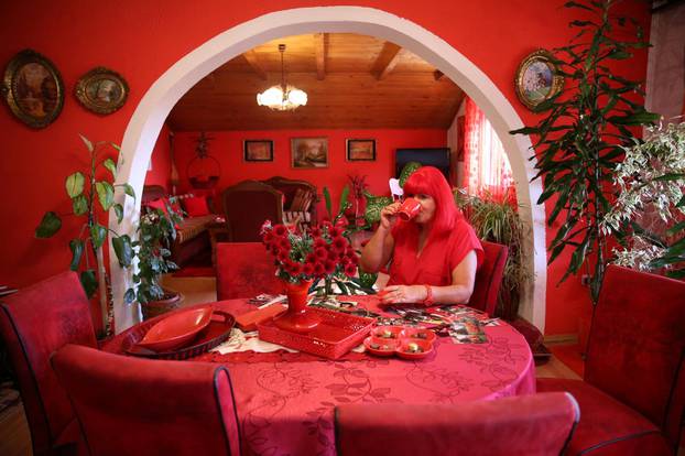 Zorica Rebernik, obsessed with the red color, drinks coffee in her house in the village of Breze near Tuzla