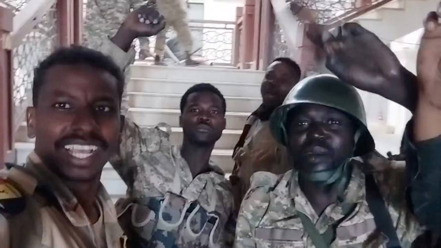 Sudanese army members film themselves inside the presidential palace in Khartoum