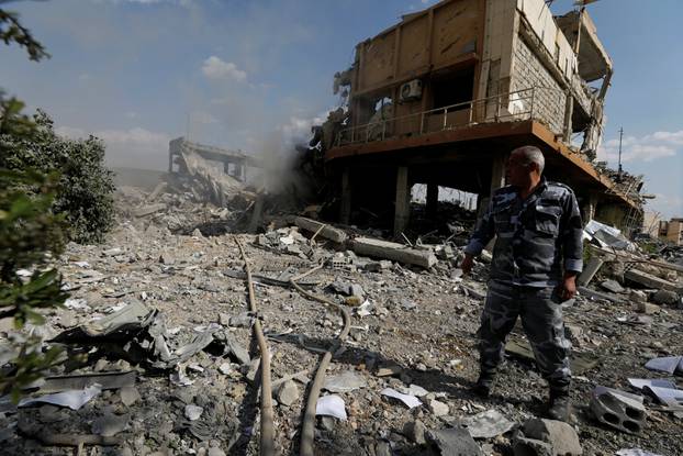 A Syrian firefighter is seen inside the destroyed Scientific Research Centre in Damascus