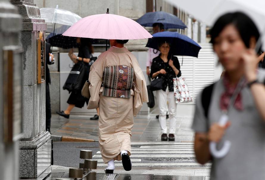Woman, dressed in a traditional Japanese kimono, holds an umbrella as she walk on a street as Typhoon Malakas approaches the region in Tokyo