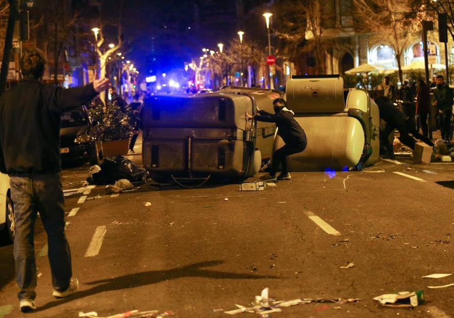 Protestors erect barricades on a street during skirmishes with police after former regional president Carles Puigdemont was detained in Germany,  in Barcelona