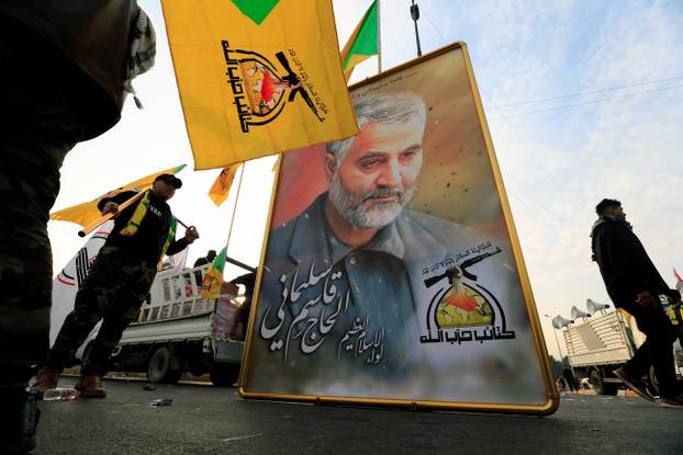 Kataib Hezbollah Iraqi militia hold the picture of the Iranian Major-General Qassem Soleimani, as they gather ahead of the funeral of the Iraqi militia commander Abu Mahdi al-Muhandis, in Baghdad