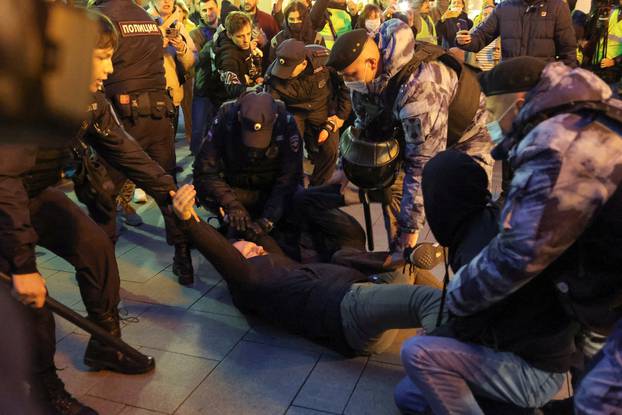Russian police officers detain a man during an unsanctioned rally in Moscow