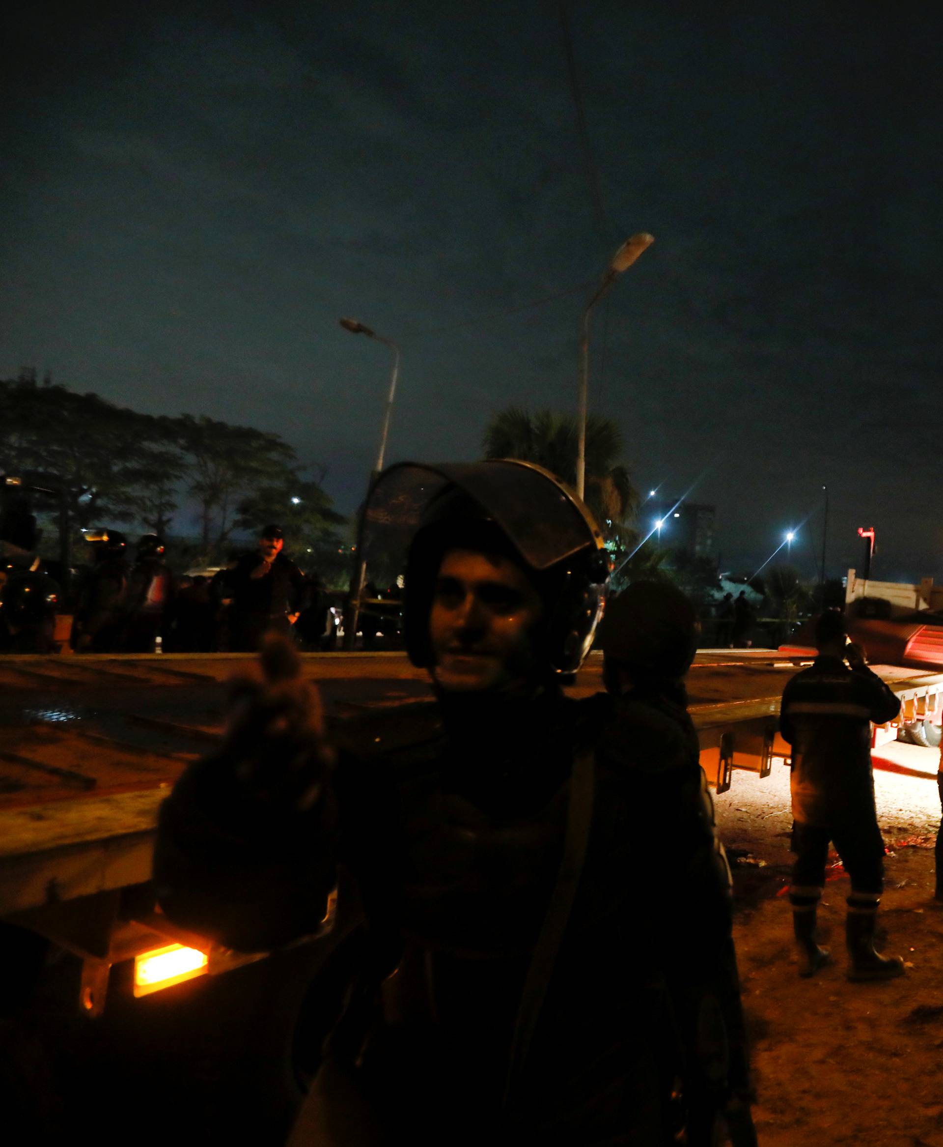 Riot police secure a scene of a bus blast in Giza