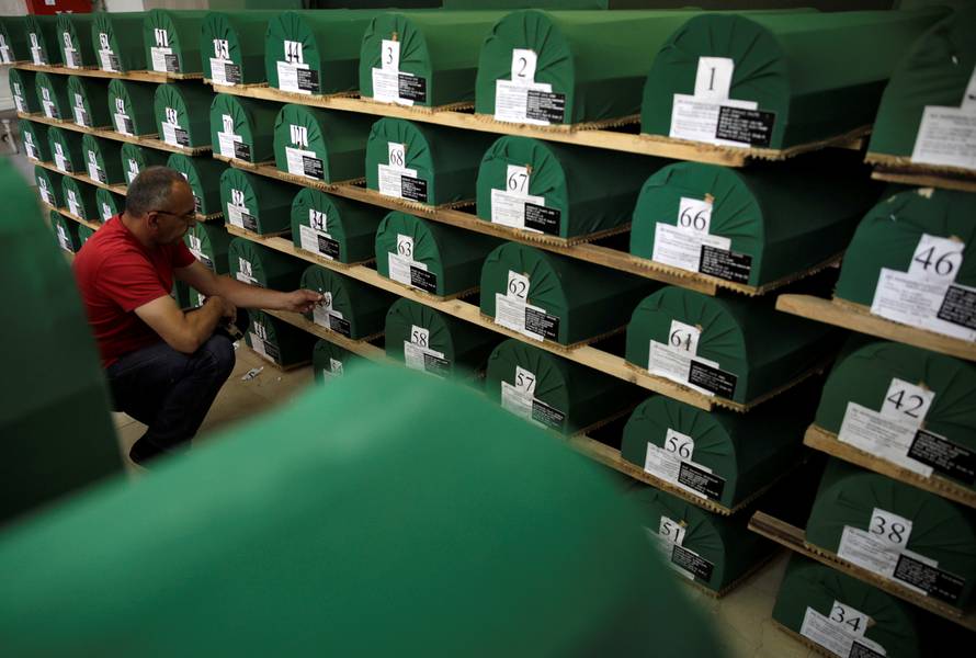 A worker prepares coffins containing the remains of victims from the 1995 Srebrenica massacre, at a morgue in the central Bosnian town of Visoko