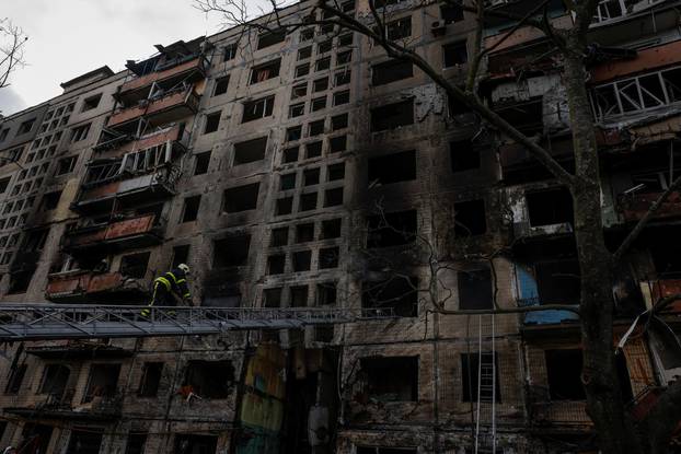 A firefighter enters a residential building that was hit by a shell in the Obolon district in Kyiv