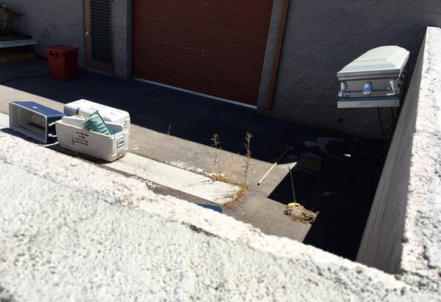 A coffin, mops and coolers used to transport body parts lie in an abandoned courtyard outside a warehouse  in suburban Las Vegas