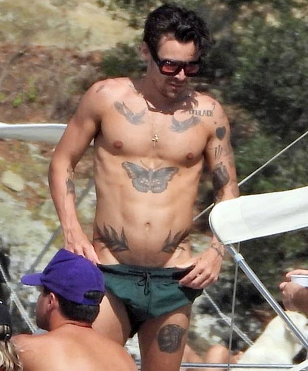 *PREMIUM-EXCLUSIVE* MUST CALL FOR PRICING BEFORE USAGE  - Harry Styles shows off his toned physique and his impressive array of tattoos on his Italian holiday with friends James Corden and Victoria's Secrets lingerie model Jacquelyn Jablonski out on Lake