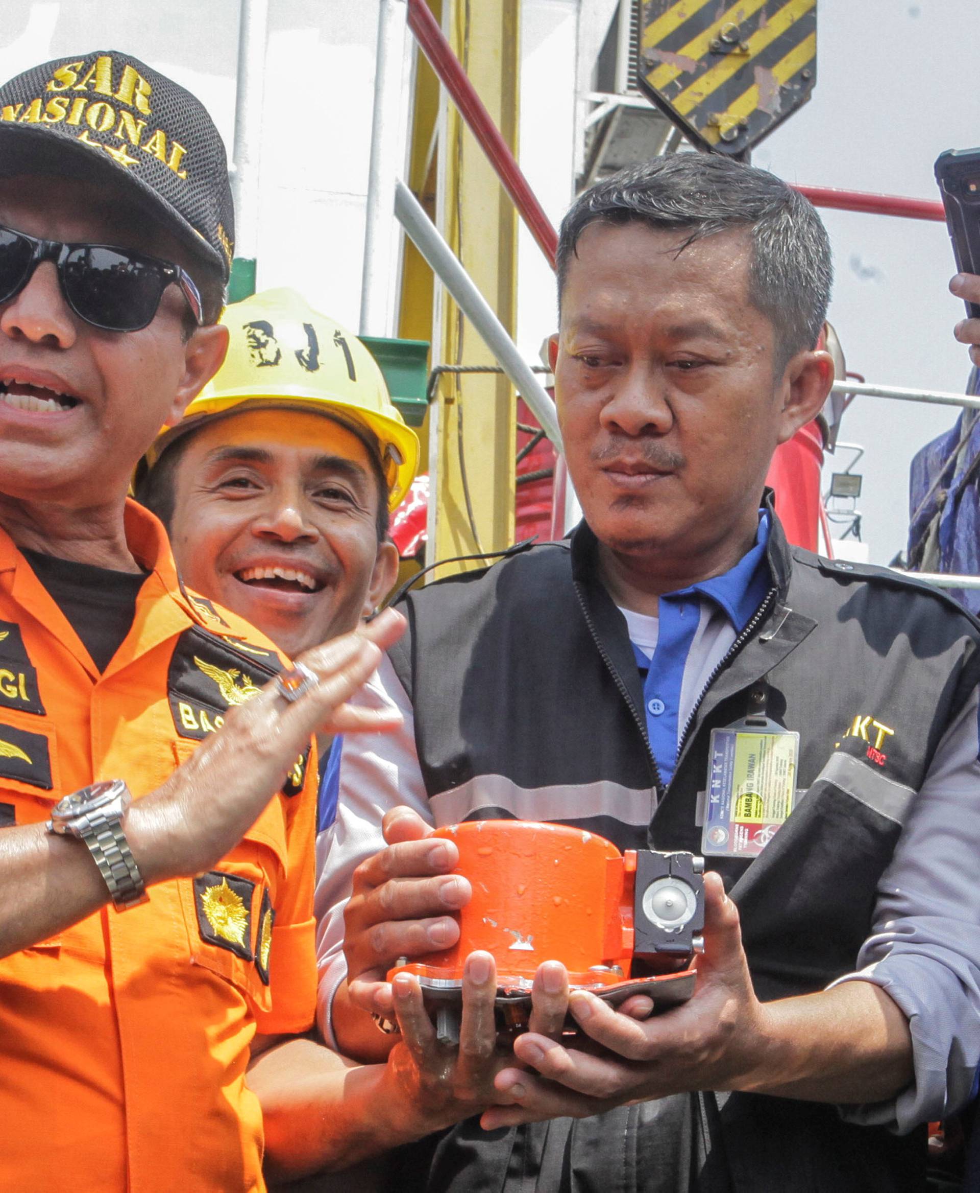 Chief of National Search and Rescue Agency Muhammad Syaugi (L) shows part of the black box of  Lion Air's flight JT610 airplane, on Baruna Jaya ship, in the north sea of Karawang