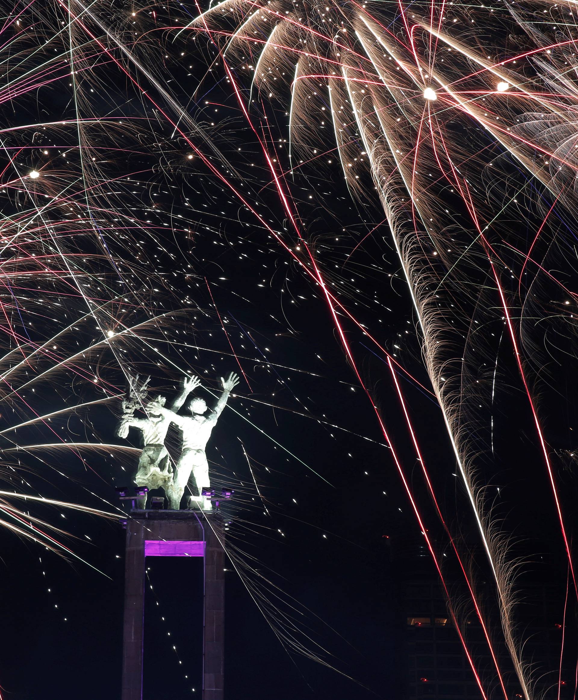 Fireworks explode around the Selamat Datang Monument during New Year's Eve celebrations in Jakarta