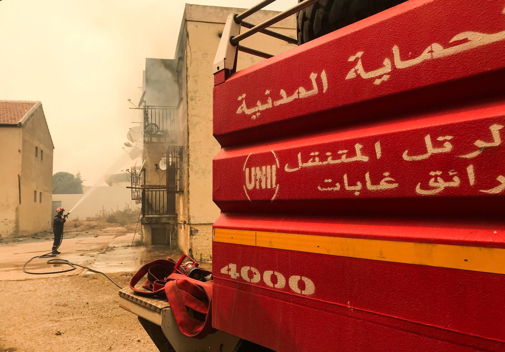 A firefighter attempts to put out a fire at a building in Ain al-Hammam village