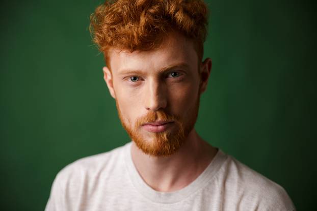 Close-up portrait of curly redhead young man with beard