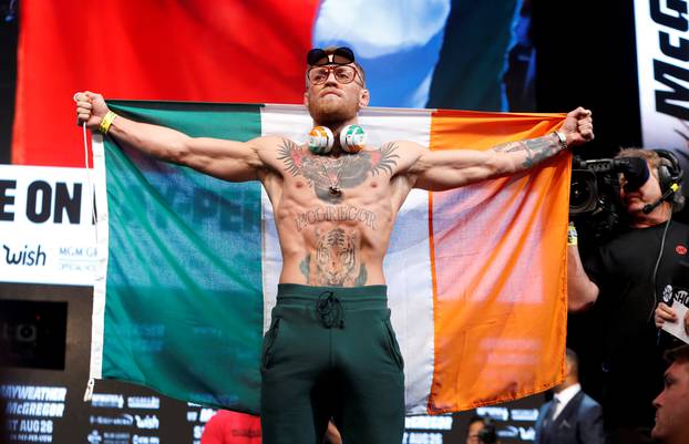 UFC lightweight champion Conor McGregor of Ireland arrives on stage for his official weigh-in at T-Mobile Arena in Las Vegas