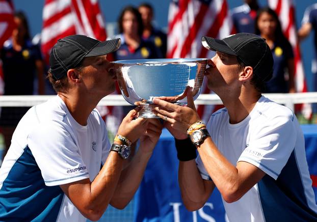 FILE PHOTO: Bob and Mike Bryan of the U.S. kiss their trophy after they defeated Granollers and Lopez of Spain in their men