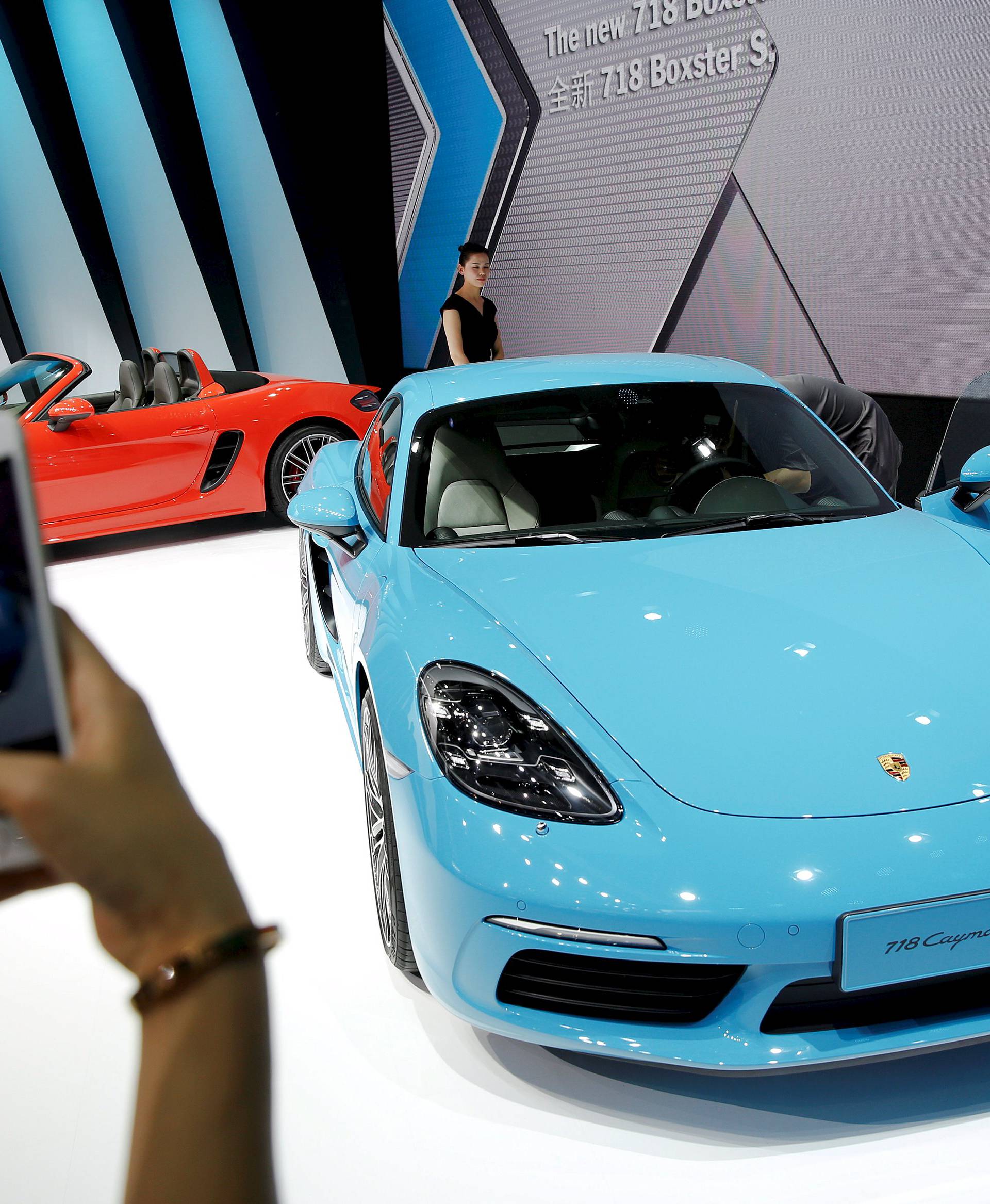 A visitor takes pictures of a new Porsche 718 Cayman S presented during Auto China 2016 auto show in Beijing