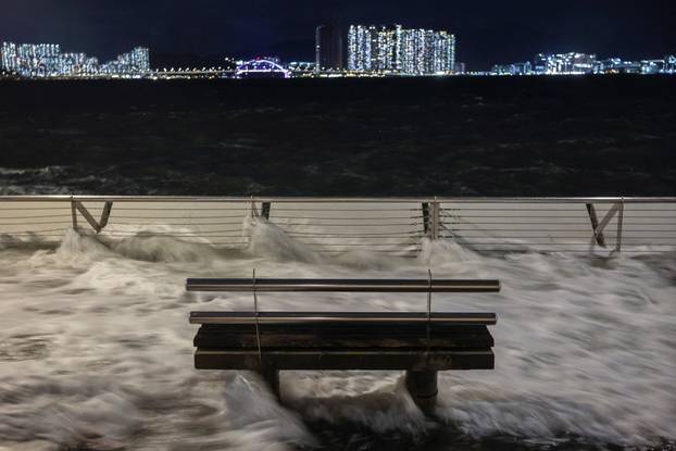 Waves from Super Typhoon Ragasa crash onto chair by the shore in Hong Kong