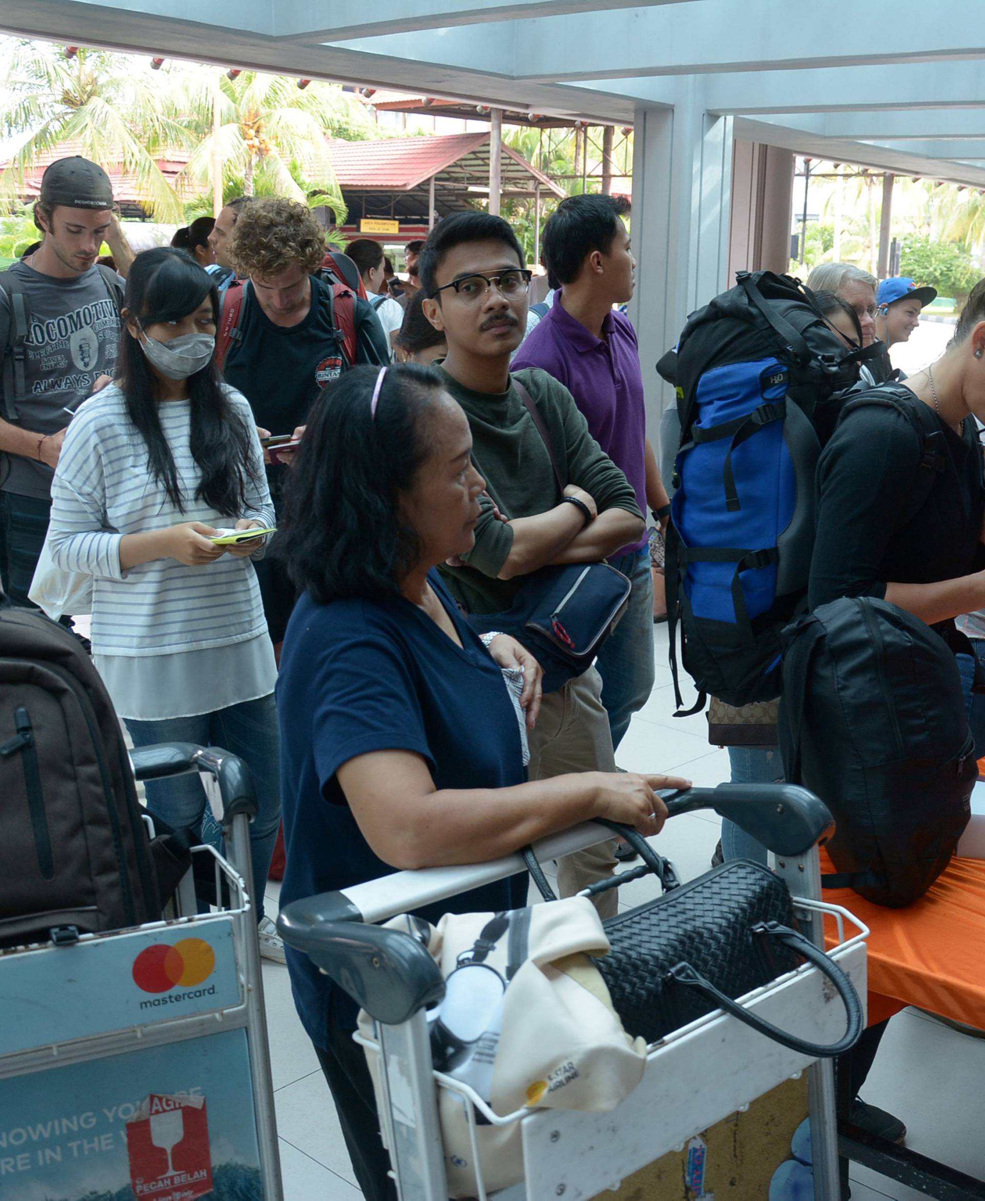 Tourists try to obtain flight information following the closure of Ngurah Rai airport in Denpasar