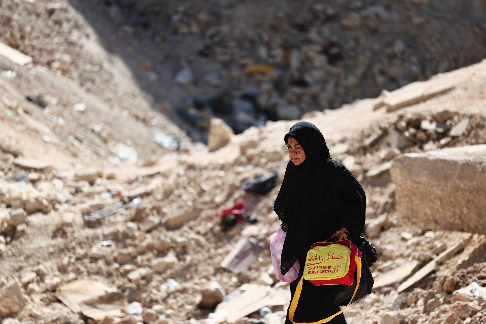 People cross from Lebanon into Syria as they flee the ongoing hostilities between Hezbollah and Israeli forces