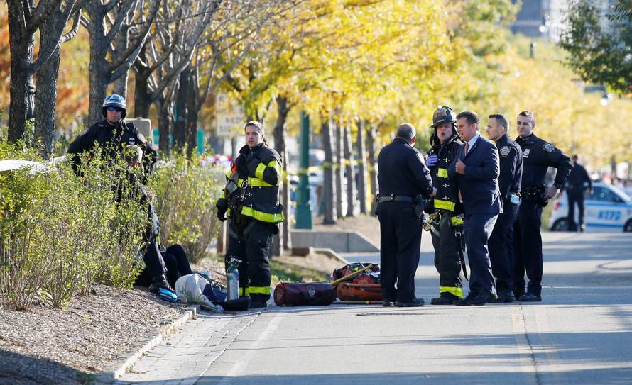 New York city first responders stand at the crime scene on a bike path in lower Manhattan in New York