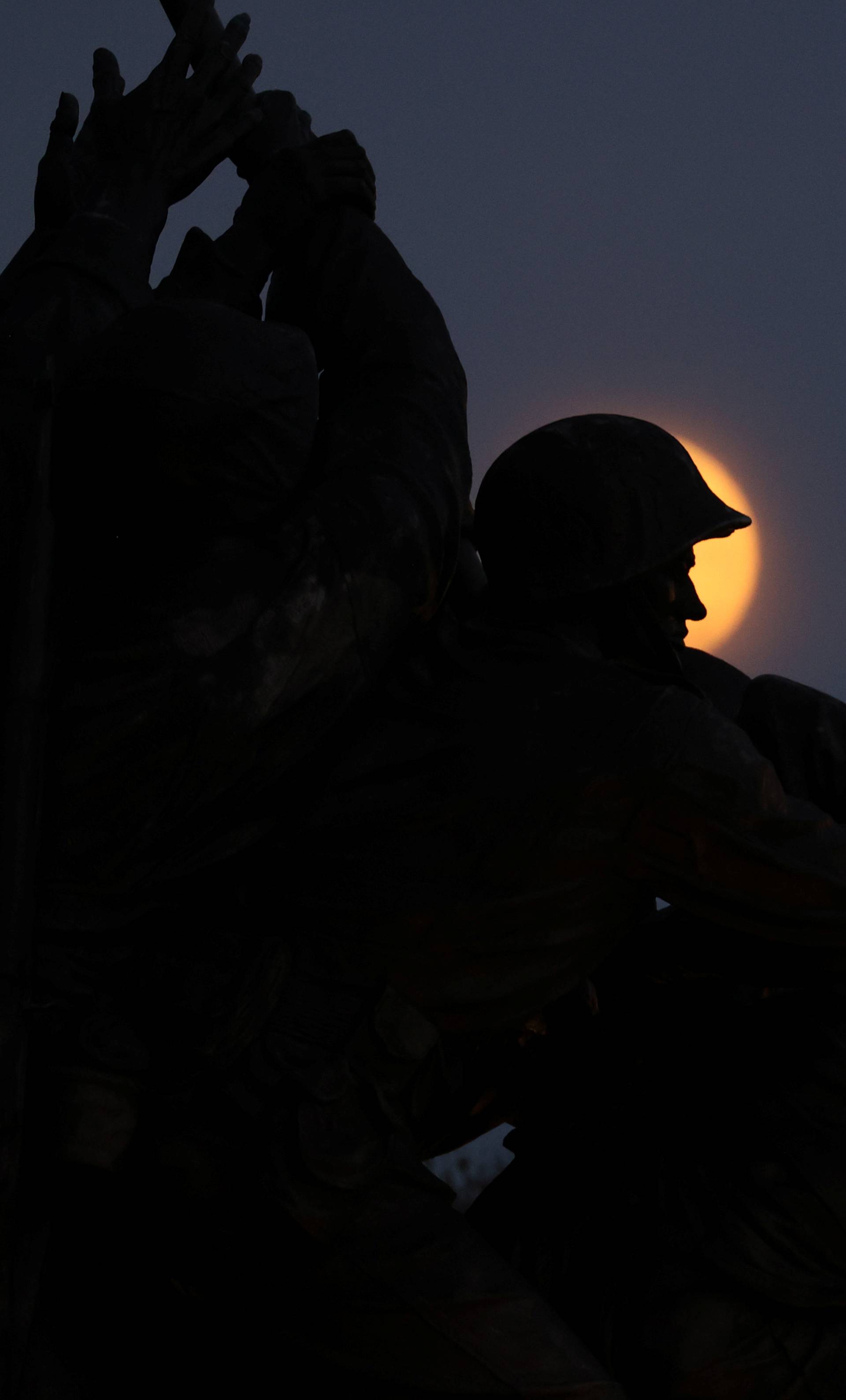 A rising supermoon frames the statue of soldiers in the U.S. Marine Corps War Memorial, depicting the WWII flag raising on Iwo Jima, in Arlington, Virginia