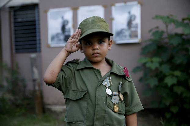 Child salutes while awaiting the caravan carrying Castro
