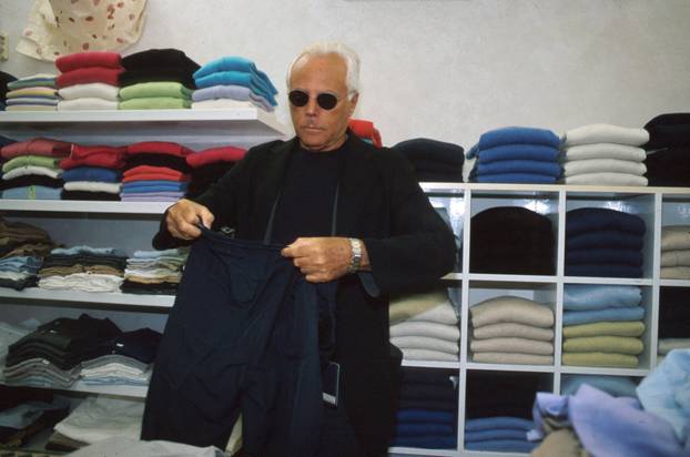 FILE PHOTO: Designer Giorgio Armani arranges clothes in his boutique