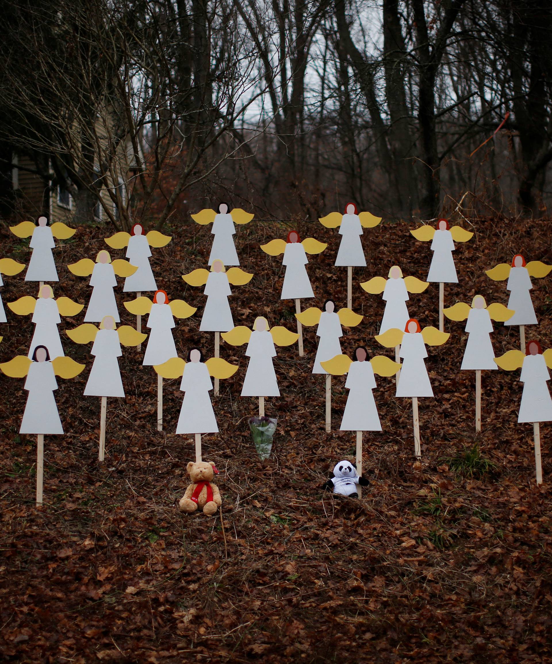 FILE PHOTO: Twenty-seven wooden angel figures are seen placed in wooded area beside road near Sandy Hook Elementary School for victims of school shooting in Newtown
