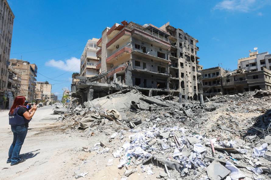 People inspect the damage in the aftermath of an Israeli strike, in Tyre