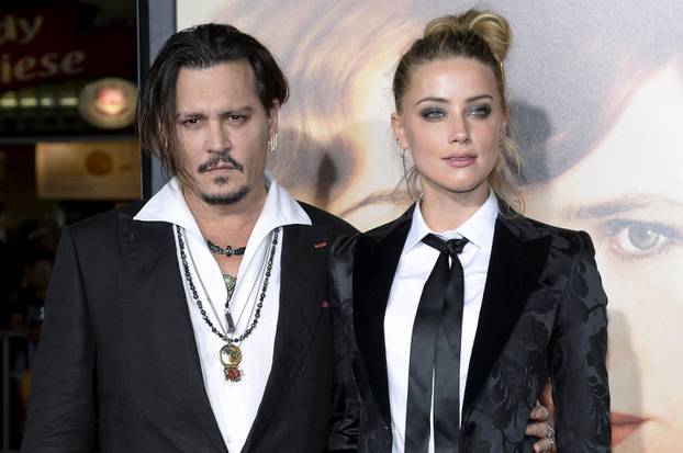 Cast member Amber Heard and husband Johnny Depp pose during the premiere of the film "The Danish Girl," in Los Angeles