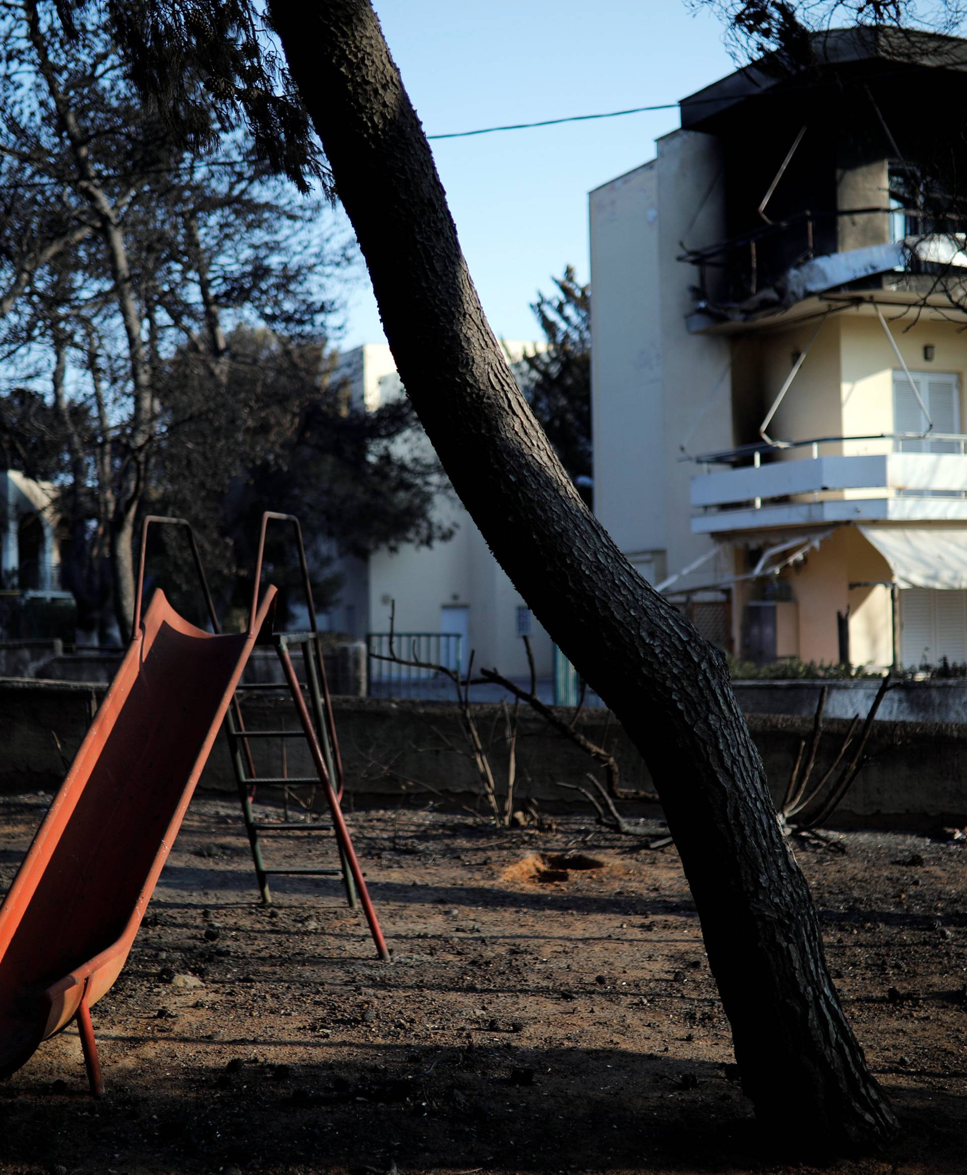 A slide is seen in a burnt playground following a wildfire at the village of Mati, near Athens