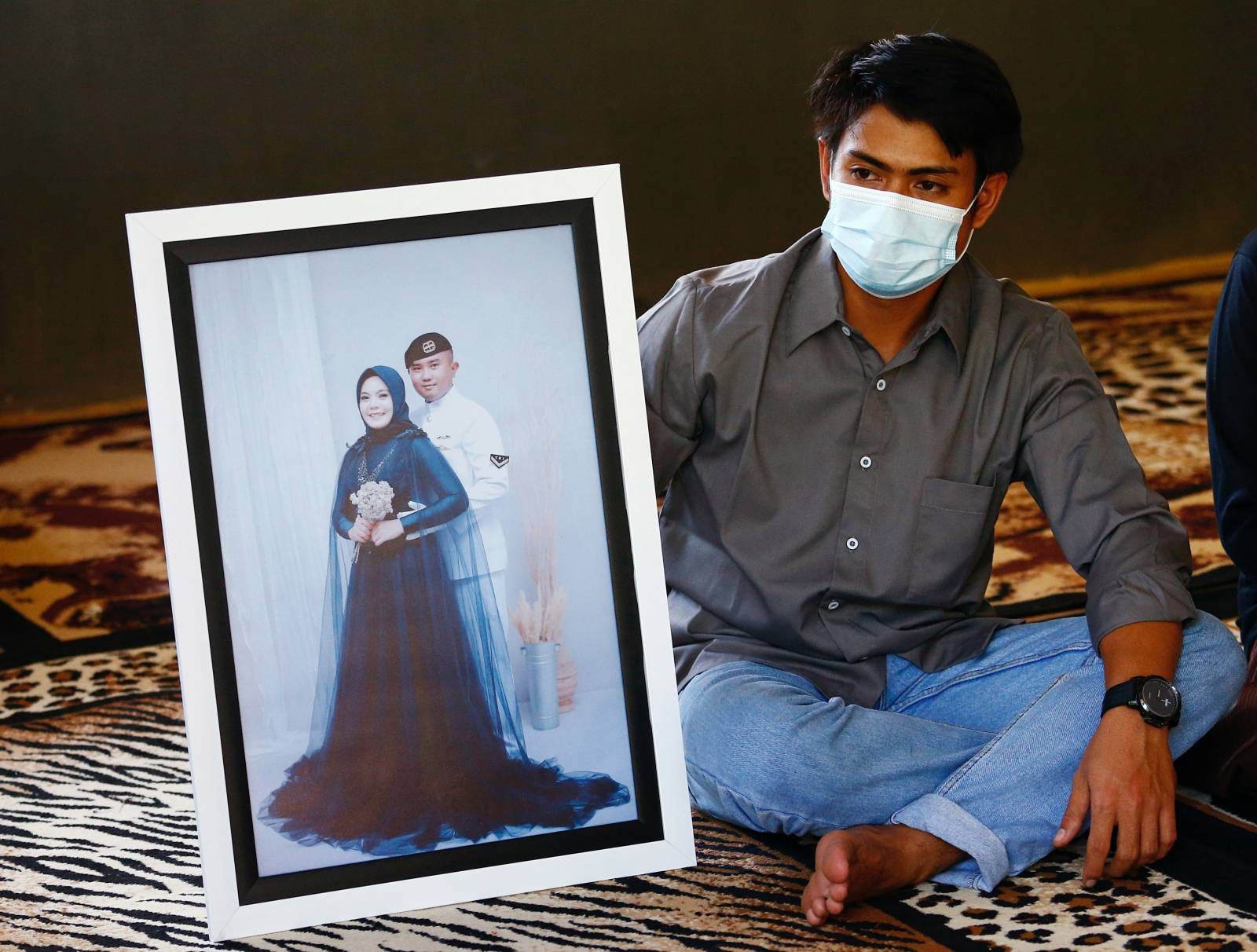 Imam Yoga, 26-year-old brother-in-law of Pandu Yudha Kusuma, 23, one of the crew members of the sunken KRI Nanggala-402 submarine, shows a photograph during an interview at his parents' house in Banyuwangi